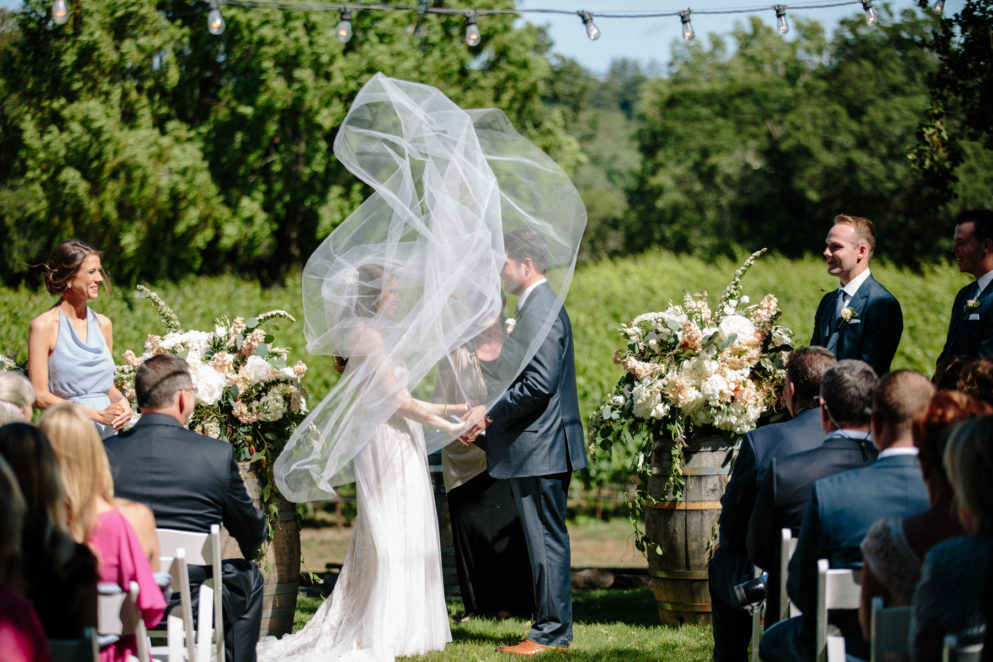 The bride's veil blowing at her outdoor ceremony at Arista Winery