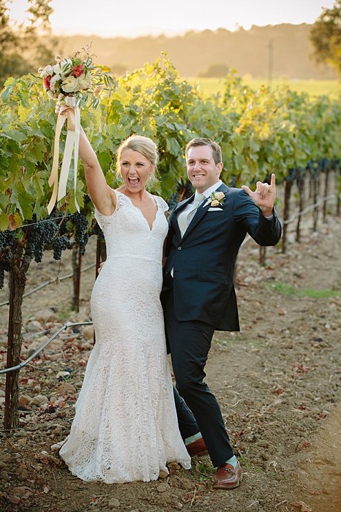 bride and groom pose by vineyard at Beltane Ranch wedding