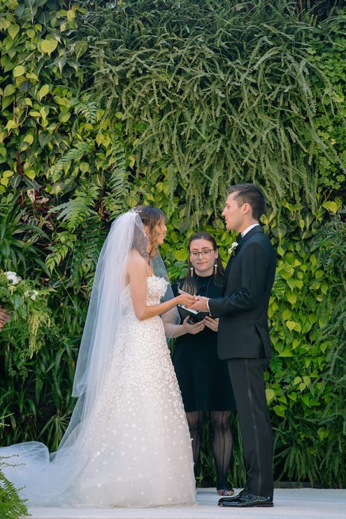 bride and groom exchange vows at california academy of sciences wedding 