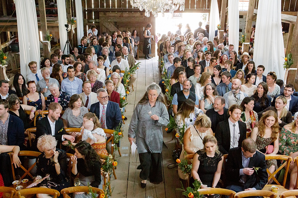 ceremony in a barn full of guests at Five Springs Ranch wedding by michelle walker photography