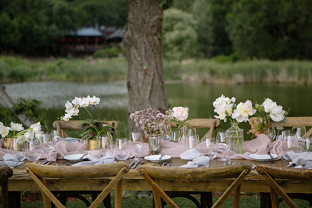 table with pond in the background at calistoga ranch wedding by michelle walker photography