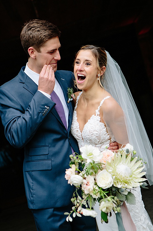 groom jokingly wipes kiss of cheek at Campovida winery wedding
