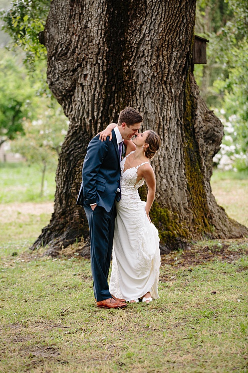 bride and groom kiss outside Campovida winery wedding