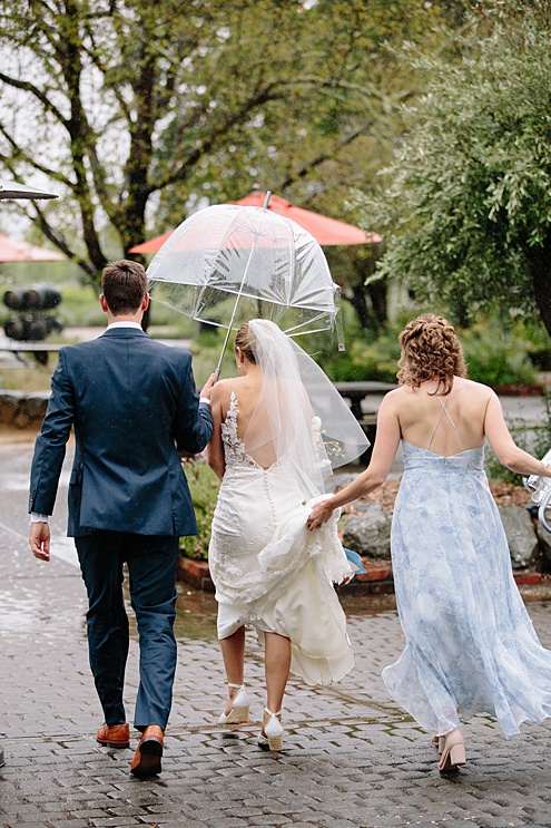 guests take shelter from the rain at Campovida winery wedding