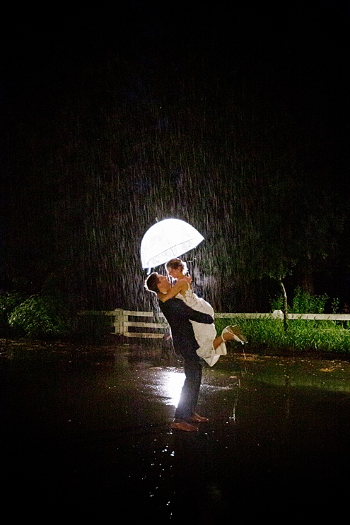 bride and groom kiss in the rain at Campovida winery wedding