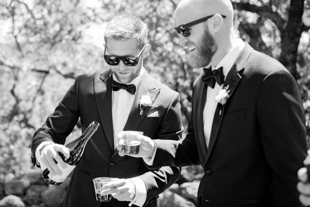 Groom and groomsmen enjoying wine before the wedding.