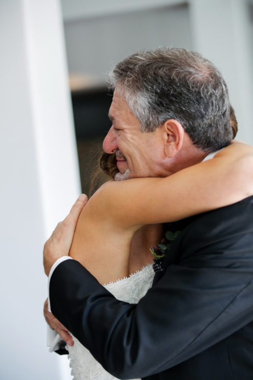 Father of the bride seeing his daughter in her wedding dress for the first time.
