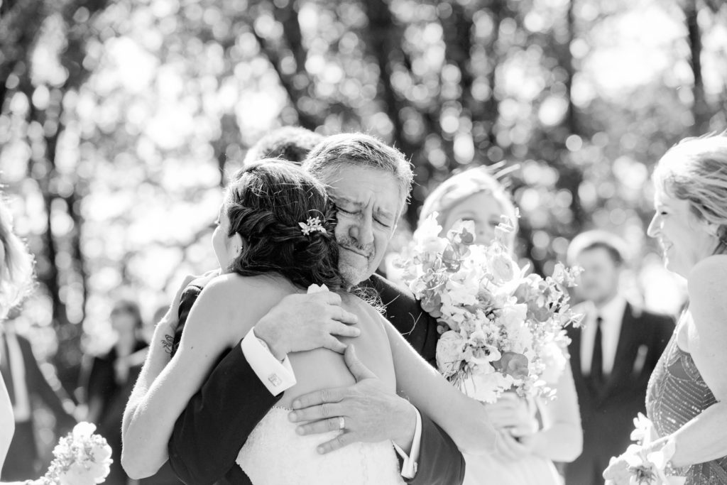 The bride hugs her dad after the wedding ceremony.